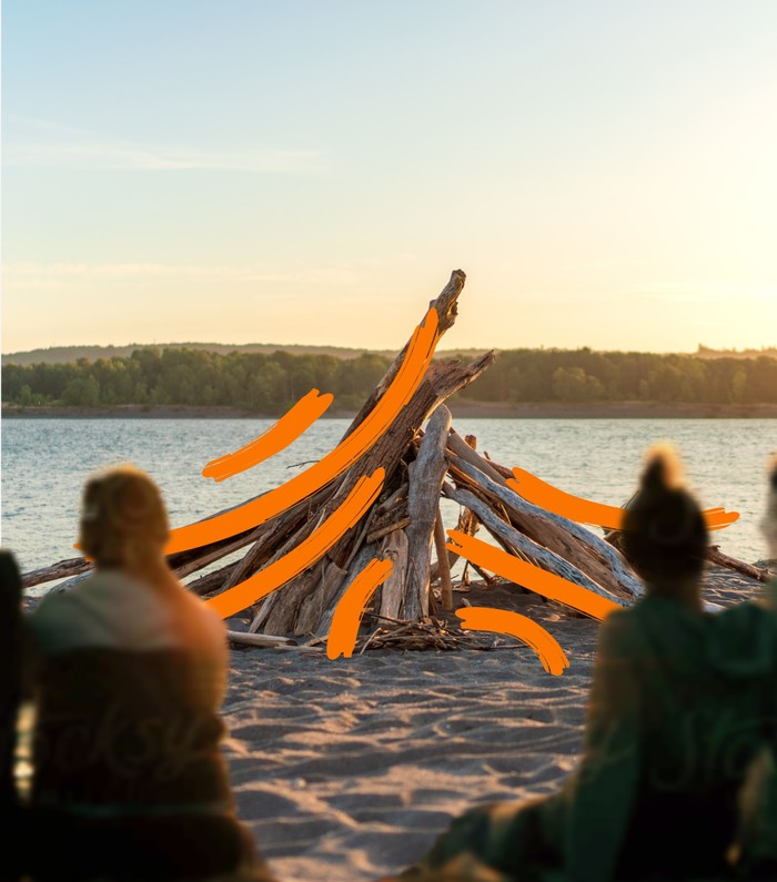Group of friends sitting on the beach in front of the Kalama river watching the sunset