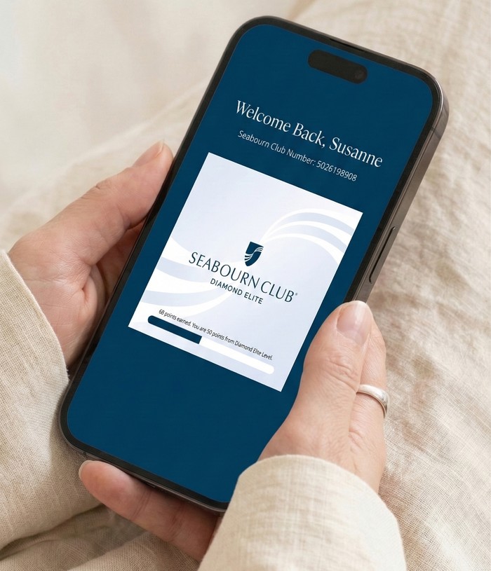 Close-up of hands holding a smartphone showing the Seabourn Club loyalty app.