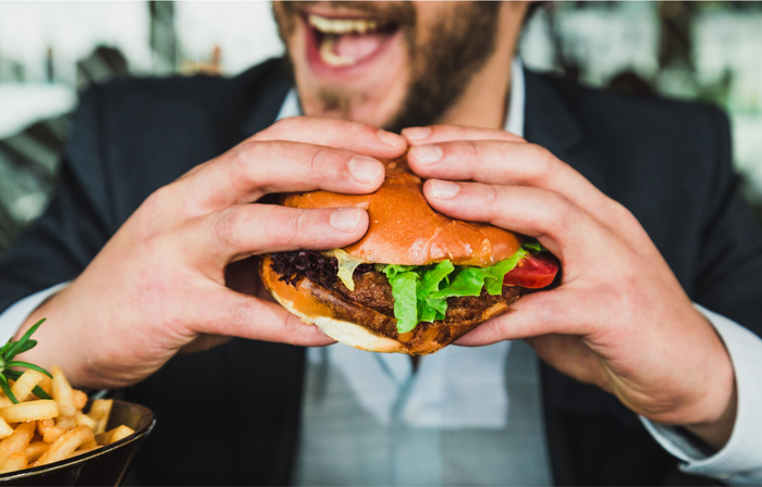 Close up of man holding sandwich while smiling